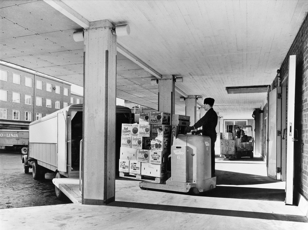 Laatikoita puretaan autosta Tukon keskusvarastolla, Panimokatu 1. Pietinen, valokuvaaja 1960-1963, Helsingin kaupunginmuseo.